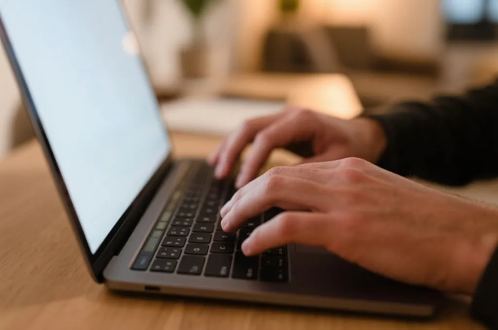 A close-up of a person typing securely on a laptop, professional home office, warm atmosphere, focused on safety and privacy